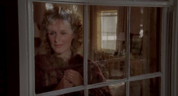 Movie still from “The Big Chill” (1983), directed by Lawrence Kasdan – A woman looking out of a window in a room; Close Up shot, Over the shoulder angle