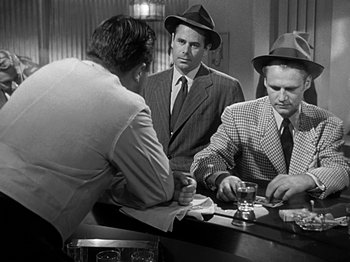 Movie still from “The Big Heat” (1953), directed by Fritz Lang – A group of men sitting at a table in a room; Medium shot, Over the shoulder angle