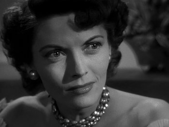 Movie still from “The Big Heat” (1953), directed by Fritz Lang – An old photo of a woman in a dress and pearls; Close Up shot, Low angle