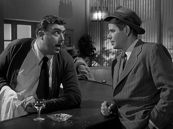 Movie still from “The Big Heat” (1953), directed by Fritz Lang – Two men sitting at a table talking to each other; Medium shot, Over the shoulder angle