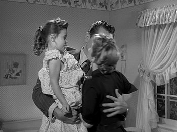 Movie still from “The Big Heat” (1953), directed by Fritz Lang – An old photo of a man and two children; Medium shot, High angle