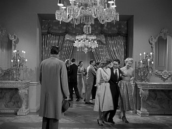 Movie still from “The Big Heat” (1953), directed by Fritz Lang – A black and white photo of a group of people in formal wear; Wide shot, Low angle