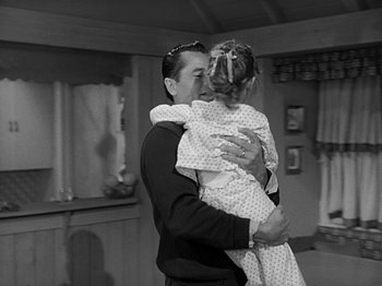 Movie still from “The Big Heat” (1953), directed by Fritz Lang – A black and white photo of a man holding a little girl; Medium shot, Over the shoulder angle