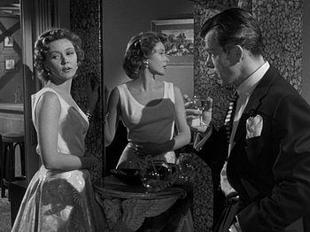 Movie still from “The Big Heat” (1953), directed by Fritz Lang – Two women and a man are standing in front of a mirror; Medium shot, Over the shoulder angle