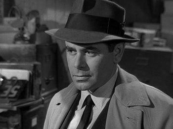 Movie still from “The Big Heat” (1953), directed by Fritz Lang – A black and white photo of a man wearing a hat; Close Up shot, Over the shoulder angle