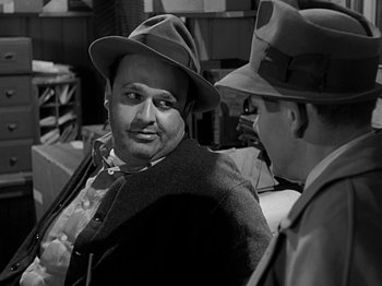Movie still from “The Big Heat” (1953), directed by Fritz Lang – A man wearing a hat and a jacket talking to another man wearing a hat; Close Up shot, Over the shoulder angle