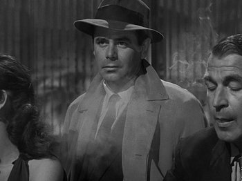 Movie still from “The Big Heat” (1953), directed by Fritz Lang – A man wearing a hat and a coat; Close Up shot, Low angle