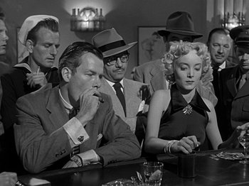Movie still from “The Big Heat” (1953), directed by Fritz Lang – A black and white photo of people sitting at a table; Medium shot, Low angle