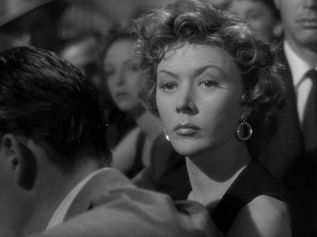 Movie still from “The Big Heat” (1953), directed by Fritz Lang – An old black and white photo of a woman in a crowd; Close Up shot, Over the shoulder angle