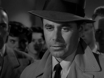 Movie still from “The Big Heat” (1953), directed by Fritz Lang – A black and white photo of a man in a hat; Close Up shot, Over the shoulder angle