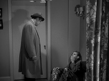 Movie still from “The Big Heat” (1953), directed by Fritz Lang – A man in a hat and a man in a trench coat and a hat; Wide shot, High angle