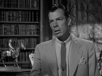 Movie still from “The Big Heat” (1953), directed by Fritz Lang – A black and white photo of a man in a suit and tie; Close Up shot, Low angle