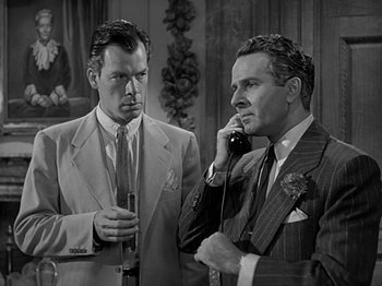 Movie still from “The Big Heat” (1953), directed by Fritz Lang – Two men in suits are talking on the phone; Medium shot, Low angle