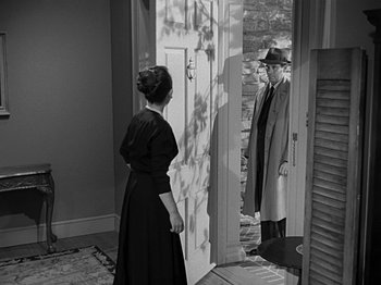 Movie still from “The Big Heat” (1953), directed by Fritz Lang – A man and a woman standing in front of an open door; Medium shot, Over the shoulder angle