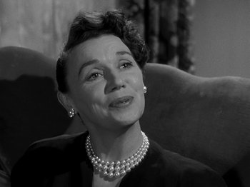 Movie still from “The Big Heat” (1953), directed by Fritz Lang – An older woman wearing pearls and a black jacket; Close Up shot, Low angle