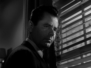 Movie still from “The Big Heat” (1953), directed by Fritz Lang – Black and white photograph of a man in a suit and tie; Close Up shot, Low angle