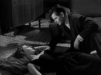 Movie still from “The Big Heat” (1953), directed by Fritz Lang – A man and a woman laying on the ground; Medium shot, High angle