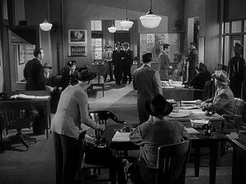 Movie still from “The Big Heat” (1953), directed by Fritz Lang – A group of people sitting at a table in a room; Wide shot, High angle