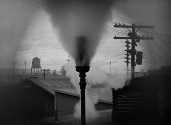 Movie still from “The Big Parade” (1925), directed by King Vidor – A black - and - white photo of a smoke stack in a city; Extreme Wide shot, Low angle