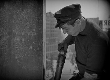 Movie still from “The Big Parade” (1925), directed by King Vidor – An older man leaning against a wall with a telescope; Medium shot, Low angle