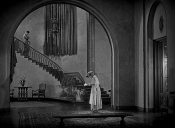 Movie still from “The Big Parade” (1925), directed by King Vidor – A woman in a white dress standing in front of a staircase; Extreme Wide shot, High angle