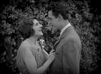 Movie still from “The Big Parade” (1925), directed by King Vidor – An old photo of a man and a woman smiling at each other; Medium shot, High angle