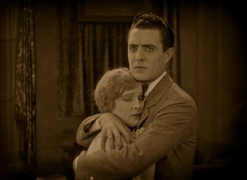 Movie still from “The Big Parade” (1925), directed by King Vidor – An old photo of a man and a woman hugging; Medium shot, High angle