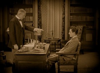 Movie still from “The Big Parade” (1925), directed by King Vidor – An old photo of two men sitting at a desk; Medium shot, High angle
