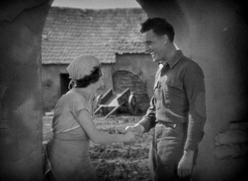 Movie still from “The Big Parade” (1925), directed by King Vidor – An old photo of a man and a woman shaking hands; Medium shot, High angle