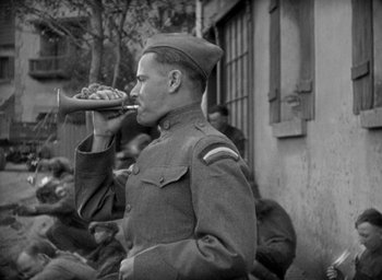 Movie still from “The Big Parade” (1925), directed by King Vidor – An old photo of a man in a uniform eating food; Medium shot, High angle
