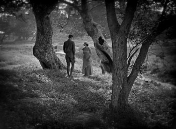 Movie still from “The Big Parade” (1925), directed by King Vidor – A man and a woman standing next to each other in the woods; Wide shot, High angle