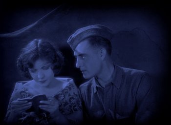 Movie still from “The Big Parade” (1925), directed by King Vidor – A man and a woman looking at a cell phone; Medium shot, High angle