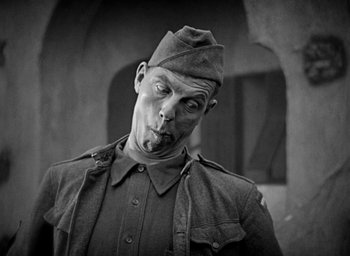 Movie still from “The Big Parade” (1925), directed by King Vidor – A man in a military uniform is posing for a picture; Close Up shot, Low angle