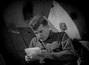 Movie still from “The Big Parade” (1925), directed by King Vidor – An old photo of a man reading a piece of paper; Medium shot, Low angle