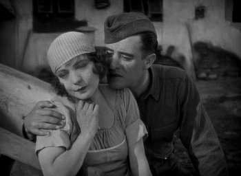 Movie still from “The Big Parade” (1925), directed by King Vidor – An old photo of a man kissing a woman on the cheek; Medium shot, High angle