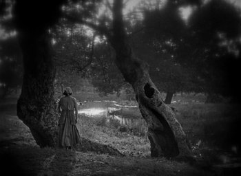 Movie still from “The Big Parade” (1925), directed by King Vidor – A person standing next to a tree in the woods; Extreme Wide shot, High angle