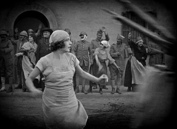 Movie still from “The Big Parade” (1925), directed by King Vidor – An old photo of a woman playing a game of baseball; Wide shot, Low angle