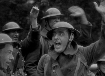 Movie still from “The Big Parade” (1925), directed by King Vidor – An old photo of a man in a trench coat and hat; Medium shot, Low angle