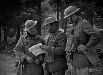 Movie still from “The Big Parade” (1925), directed by King Vidor – A group of men standing next to each other in the woods; Medium shot, High angle