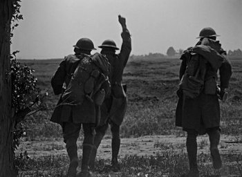 Movie still from “The Big Parade” (1925), directed by King Vidor – A black and white photo of a group of men walking across a field; Wide shot, Low angle