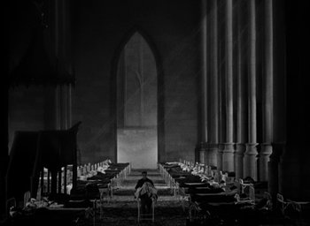 Movie still from “The Big Parade” (1925), directed by King Vidor – A man sitting in front of an organ in an old church; Extreme Wide shot, High angle