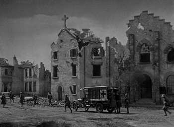 Movie still from “The Big Parade” (1925), directed by King Vidor – An old photo of some people and an old car; Extreme Wide shot, Low angle