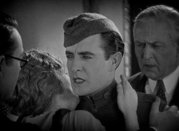Movie still from “The Big Parade” (1925), directed by King Vidor – An old photo of a man and a woman; Close Up shot, Over the shoulder angle