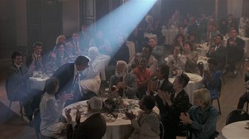 Movie still from “The Big Picture” (1989), directed by Christopher Guest – A group of people sitting around a table; Wide shot, Over the shoulder angle