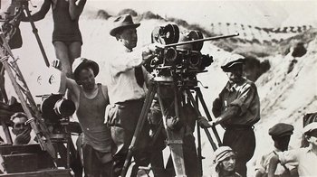Movie still from “The Big Picture” (1989), directed by Christopher Guest – A group of people standing around a camera; Medium shot, Low angle