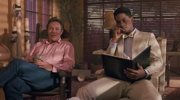 Movie still from “The Big Picture” (1989), directed by Christopher Guest – Two men are sitting in a living room; Medium shot, Over the shoulder angle