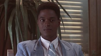 Movie still from “The Big Picture” (1989), directed by Christopher Guest – A man in a suit and tie in front of a plant; Close Up shot, Low angle