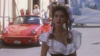 Movie still from “The Big Picture” (1989), directed by Christopher Guest – A woman in a white dress standing in front of a red car; Close Up shot, Over the shoulder angle