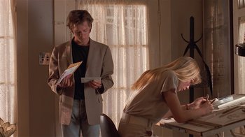 Movie still from “The Big Picture” (1989), directed by Christopher Guest – A man and a woman standing next to each other in front of a desk; Medium shot, Low angle