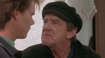Movie still from “The Big Picture” (1989), directed by Christopher Guest – An older man wearing a black hat talking to a younger man; Close Up shot, Over the shoulder angle
